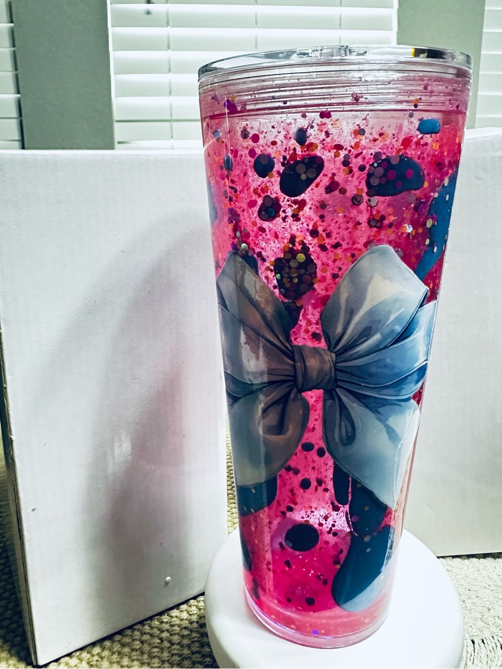 24-ounce tumbler with a bow design and a pink and blue lava effect.